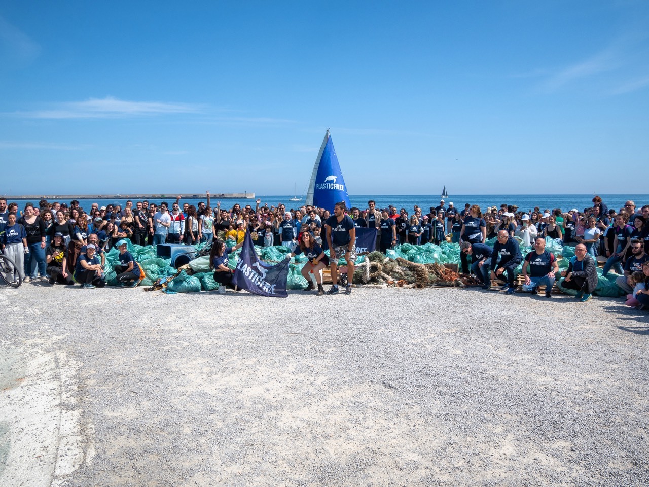 Operatrice di Save the Children in maglia rossa, seduta a un tavolo, mentre segue un'attività di doposcuola a bambini.